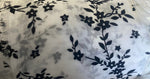 Load image into Gallery viewer, Black floral flocking on white sparkling orgaza fabric 45” wide
